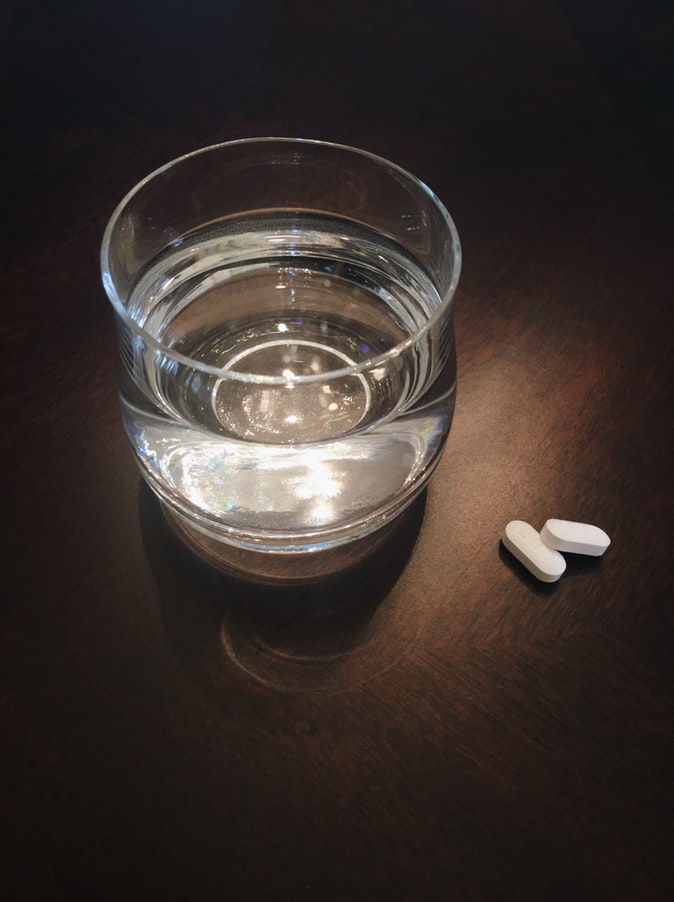 Medication next to glass of water