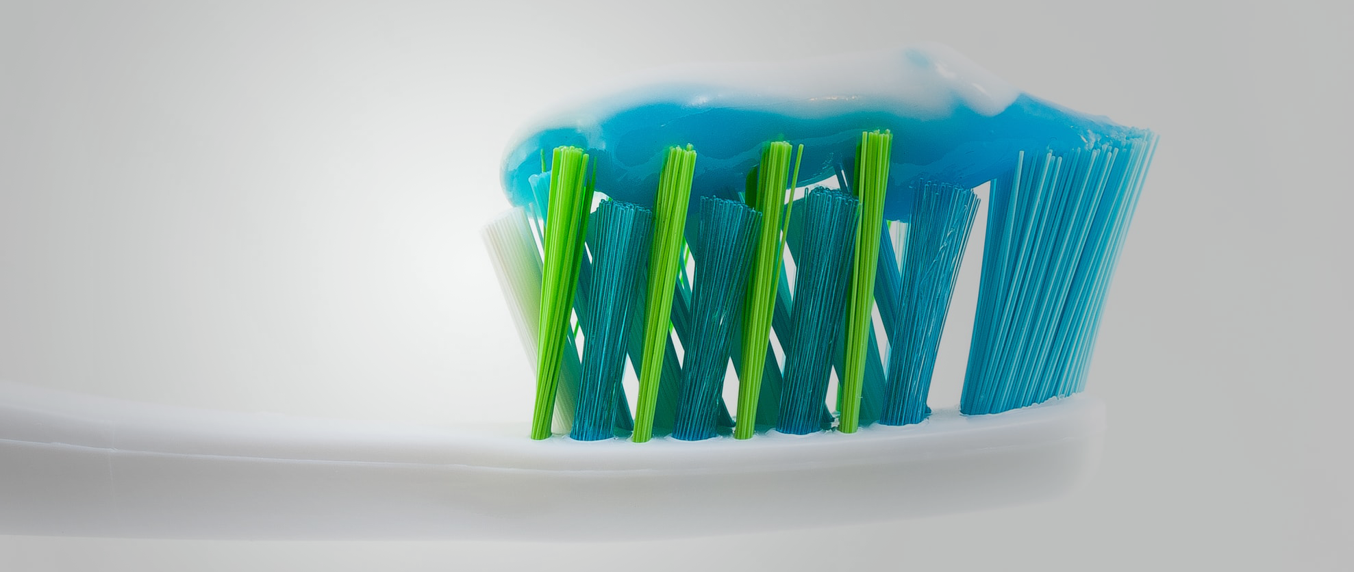 toothpaste on blue green toothbrush