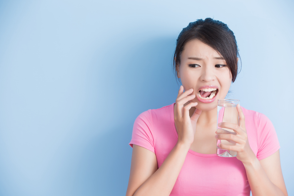 Woman drinking water and hurting