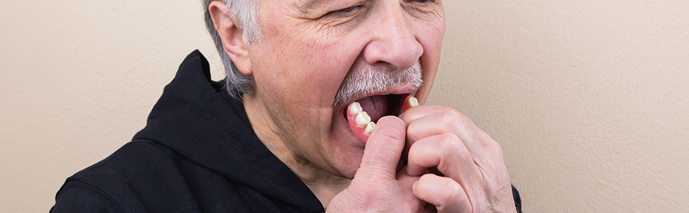 Man putting in dentures
