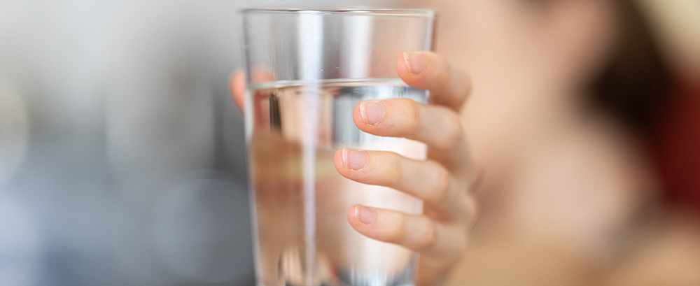Water glass held by person