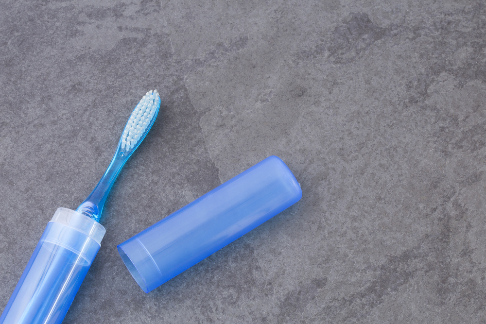 a travel toothbrush on a counter in a plastic case